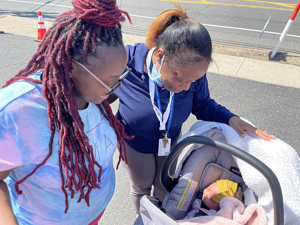 Boost NJ2 - SJFMC Women’s Health Coordinator Siobhan Moody meets one of her patients newborns with a smile!